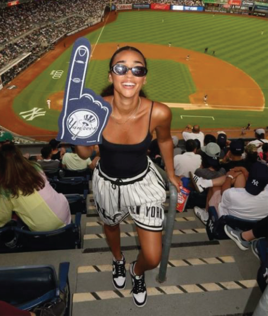 jersey athletic shorts styled with fitted tank sneakers and sunglasses at baseball game