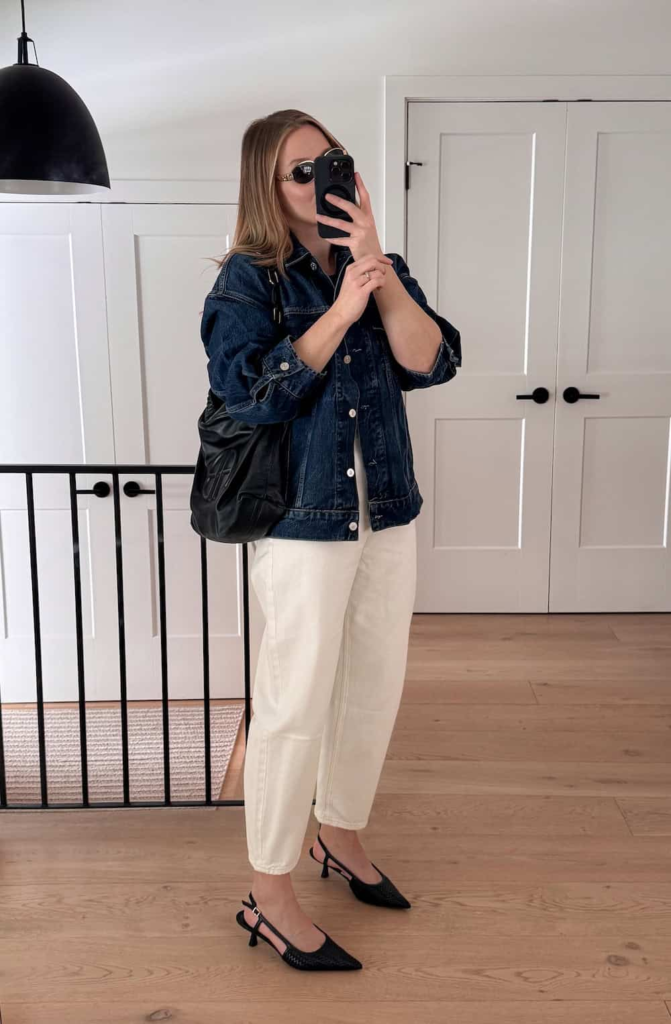 Woman wearing off-white barrel-leg jeans with a light denim jacket, a fitted neutral top, and beige slingback kitten heels.