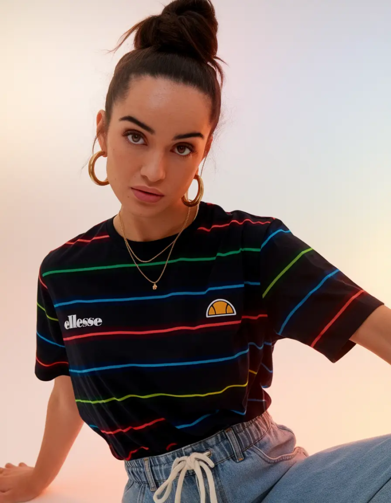 Oversized black striped t-shirt with multicolor stripes paired with relaxed drawstring jeans and white sneakers for a comfy school outfit