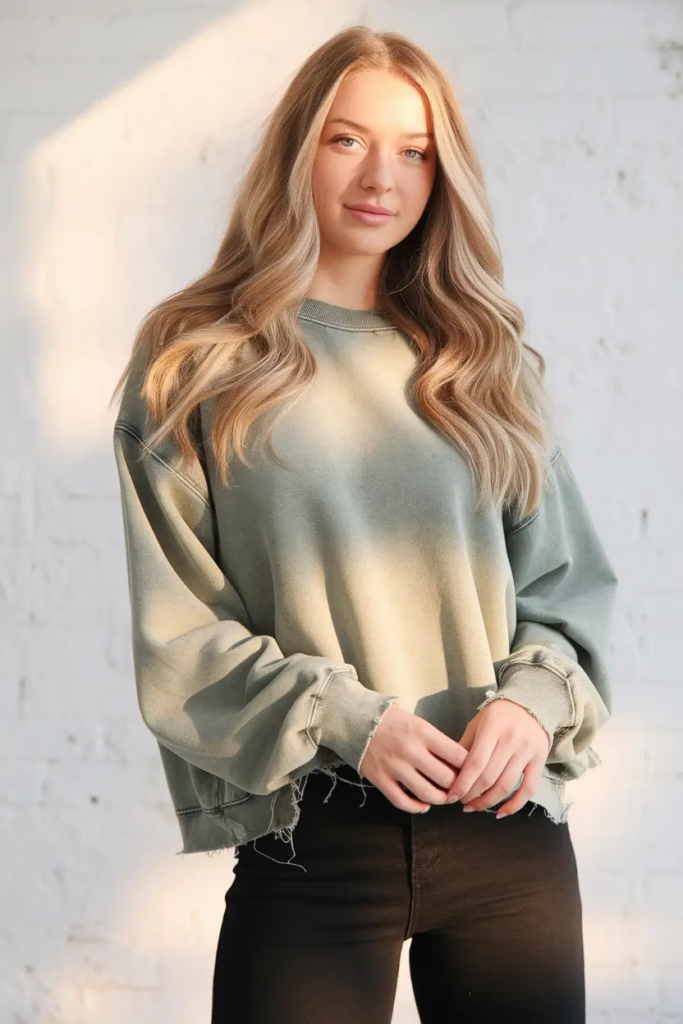 Sage green frayed hem crewneck paired with black sweatpants and white sneakers for an artsy, relaxed school outfit