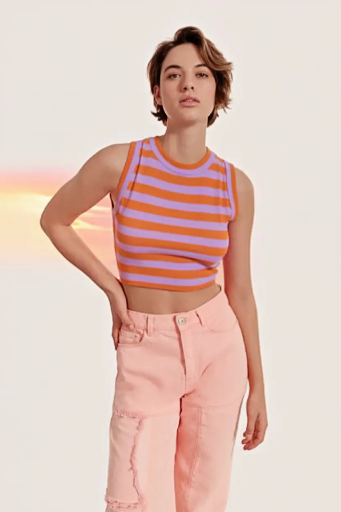 Striped sleeveless tank paired with soft pink jeans and neutral sneakers for a bright, casual school outfit