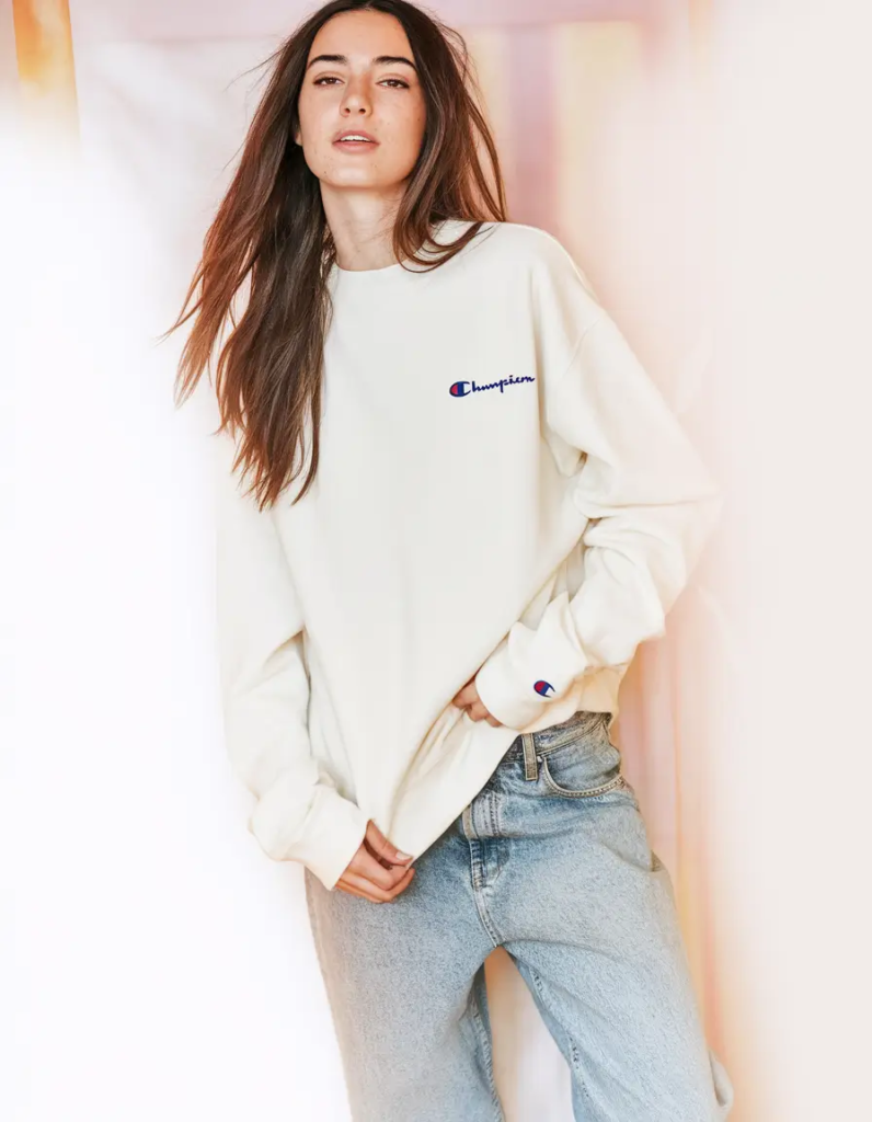 Crisp white embroidered sweatshirt paired with faded relaxed-fit jeans and low-top sneakers for a classic school outfit