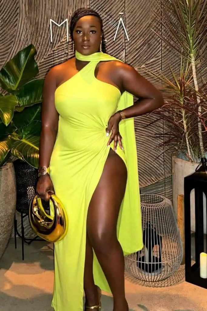 Woman wearing a neon yellow halter maxi dress with a high slit, accessorized with a sleek gold clutch and minimalist jewelry, standing on a sunlit tropical terrace.