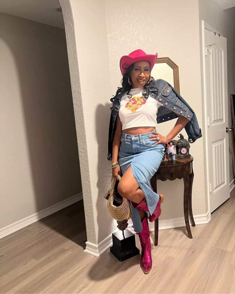 Pink cowboy hat and matching knee-high boots styled with denim jacket and slit denim skirt for a playful baddie cowgirl outfit.