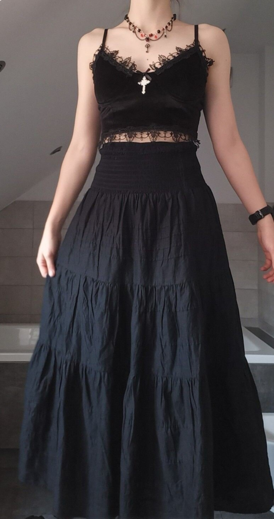 Black lace crop top paired with flowing tiered maxi skirt and beaded choker in a dark romantic boho goth outfit