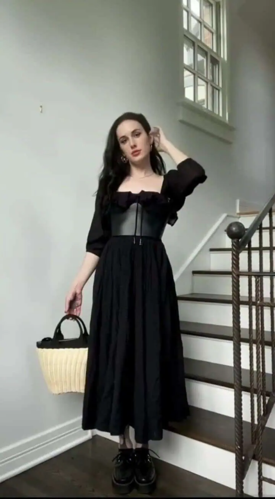Off-shoulder black midi dress paired with natural woven basket bag and black platform boots in a boho goth outfit